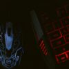 Close-up of a glowing gaming mouse and a backlit keyboard in a dim setting, showcasing a tech-savvy setup.