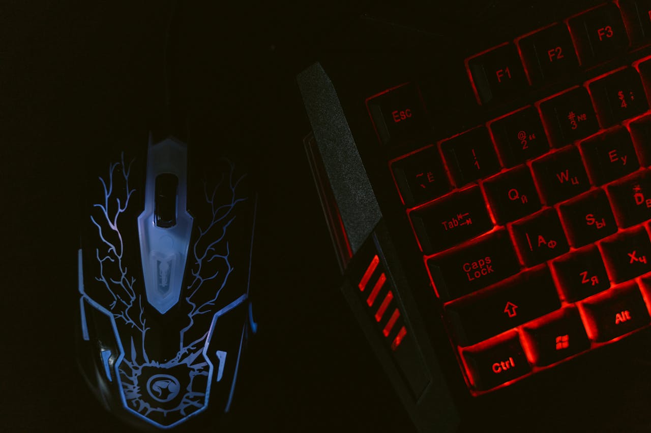 Close-up of a glowing gaming mouse and a backlit keyboard in a dim setting, showcasing a tech-savvy setup.